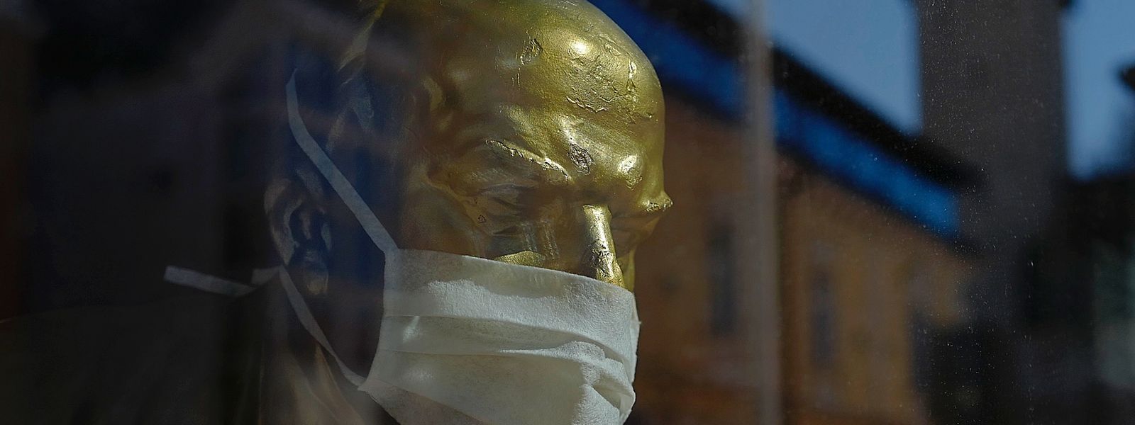 Eine Büste des russischen Revolutionärs Wladimir Lenin mit Mundschutz.