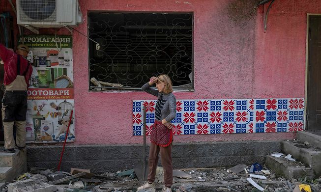 Pet shop owner Julia, 32, tries to clean the rubble of her shop after it was hit by Russian forces, in Toretsk, eastern Ukraine, on August 5, 2022