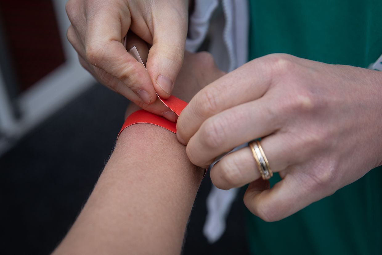 Si le test est positif, le patient est clairement identifié comme porteur du covid, à l'aide d'un bracelet rouge.