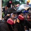 In this picture taken on August 25, 2019, Abby (L), 19, and her boyfriend Nick, 20, wait for tear gas to be fired by police as they attend a protest in Tsuen Wan, an area in the New Territories in Hong Kong. - A gas mask lovingly adjusted, a hand squeezed before approaching police lines�and a frantic search through swirls of tear gas -- Abby and Nick's relationship has blossomed on the barricades during Hong Kong's long summer of protest.� (Photo by Anthony WALLACE / AFP) / TO GO WITH AFP STORY HONG KONG-POLITICS-CHINA-UNREST-PROTEST,FOCUS BY AIDAN JONES AND JASMINE LEUNG