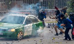 TOPSHOT - A vehicle of the Chilean Police is attacked by demonstrators during clashes which erupted during a protest against the government of President Sebastian Pinera, in Santiago, on January 24, 2020. - Demonstrations which began on October 18, 2019, initially against a modest metro fare hike, quickly escalated and left 29 people dead amid accusations of a heavy-handed response from security forces. (Photo by Martin BERNETTI / AFP)