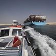 A man standing on a boat looks on as a container ship sails through the new section of the Suez Canal in the Egyptian port city of Ismailia,  135 kms northeast of the caital Cairo on October 10, 2019. - Since the Suez Canal was inaugurated amid pomp and ceremony 150 years ago, it has become one of the world's most important waterways. But its anniversary will only be discreetly marked in Egypt.
The man-made canal was excavated between 1859 and 1869, in an ambitious project to connect the Mediterranean to the Red Sea, and cut shipping times for growing international trade from Europe to Asia. (Photo by Khaled DESOUKI / AFP)