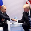 TOPSHOT - US President Donald Trump and Russia's President Vladimir Putin shake hands during a meeting on the sidelines of the G20 Summit in Hamburg, Germany, on July 7, 2017. / AFP PHOTO / SAUL LOEB