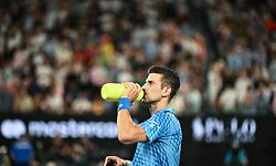 Serbia's Novak Djokovic drinks during a break as he competes against Tommy Paul of the US during their men's singles semi-final match on day twelve of the Australian Open tennis tournament in Melbourne on January 27, 2023. (Photo by ANTHONY WALLACE / AFP) / -- IMAGE RESTRICTED TO EDITORIAL USE - STRICTLY NO COMMERCIAL USE --