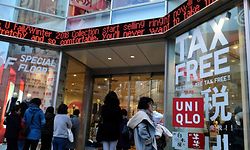 Shoppers wait at the entrance before a clothing chain store opens for business in Tokyo on December 14, 2018. - Confidence among Japan's biggest manufacturers was unchanged this quarter after slipping for three consecutive surveys, central bank data showed on December 14. (Photo by Kazuhiro NOGI / AFP)