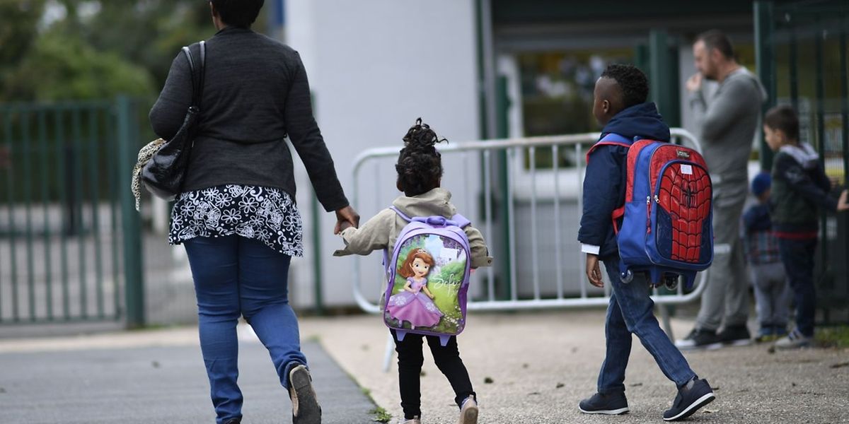 Deux enfants rentrent à l'école primaire, accompagnés de leur maman, à Corbeil-Essones, en région parisienne.