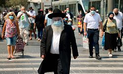 TOPSHOT - An ultra-Orthodox Jewish man wearing a protective mask and shield against the coronavirus,  walks along a street in Jerusalem on September 11, 2020. - Israel this week imposed new restrictions on parts of the country to confront a resurgence of Covid-19 infections, with the Arab-Israeli community especially hard hit in a second wave. (Photo by EMMANUEL DUNAND / AFP)