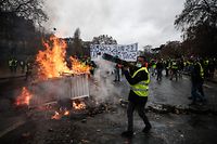 TOPSHOT - Protesters build a barricade during a protest of Yellow vests (Gilets jaunes) against rising oil prices and living costs, on December 1, 2018 in Paris. (Photo by Abdulmonam EASSA / AFP)