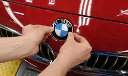 FILES- Picture taken on March 23, 2012, shows an employee fixing the logo of German carmaker BMW on a car at the end of the assembly line at the plant in Dingolfing, southern Germany. According to the company's results published on March 12, 2015, the German car manufacturer BMW increased it's sales in 2014. AFP PHOTO / CHRISTOF STACHE