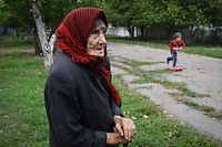 Maria Nikolyk, 83, stands on a street of the recently liberated village of Vysokopillya, Kherson region, on September 27, 2022, amid the Russian invasion of Ukraine. (Photo by Genya SAVILOV / AFP)