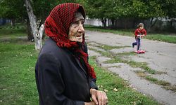 Maria Nikolyk, 83, stands on a street of the recently liberated village of Vysokopillya, Kherson region, on September 27, 2022, amid the Russian invasion of Ukraine. (Photo by Genya SAVILOV / AFP)