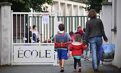 (FILES) In this file photo taken on September 4, 2017 Pupils arrive at a primary school on the first day of the new school year, in La Rochelle, western France. - French President Emmanuel Macron said during a televised speech on June 14, 2020 that all French schools, except high schools, would fully reopen from June 22, a move that will allow more parents to return to work and give students at least a few days with their teachers before the summer break. (Photo by XAVIER LEOTY / AFP)
