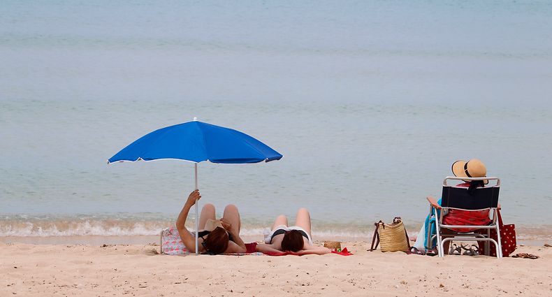 Palma de Mallorca: Menschen sonnen sich am Strand von Arenal. 