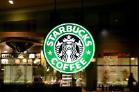 ARCHIV - 26.01.2015, Brandenburg, Potsdam: Das Logo von Starbucks leuchtet an einer Filiale des Unternehmens. Das EU-Gericht in Luxemburg urteilt am 24.09.2019 über unerlaubte Steuervorteile von Starbucks in den Niederlanden. Die EU-Kommission hatte 2015 entschieden, dass Starbucks seit 2008 in den Niederlanden unerlaubte Steuervorteile in Millionenhöhe erhalten habe. Das Land müsse eine noch zu berechnende Summe zurückfordern. Sowohl Starbucks als auch die Niederlande klagen dagegen. Foto: Ralf Hirschberger/zb/dpa +++ dpa-Bildfunk +++