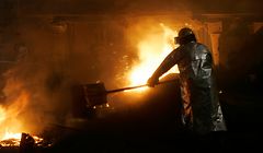 Joe Kamiel throws insulation on top of molten iron and slag as it flows from a blast furnace at Mittal Steel-USA Thursday, June 8, 2006, in Burns Harbor, Ind. Mittal, which selected Chicago as its U.S. headquarters, said Wednesday, July 26, that shareholders representing 92 percent of Arcelor had agreed to its takeover offer in a deal that will form a steel titan with control of nearly 10 percent of global production. (AP Photo/M. Spencer Green)