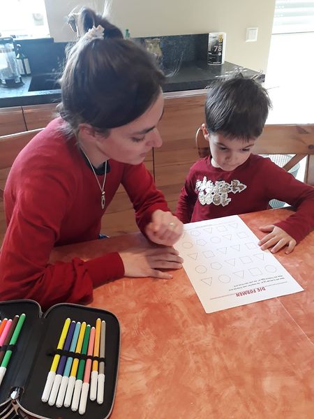 Joyce Aniset lernt mit Sohn Mathieu am Küchentisch.