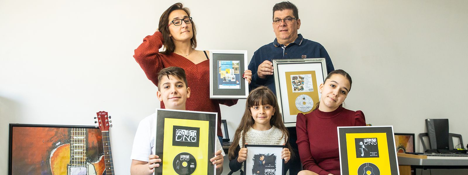 O casal João e Anabela Reboredo com os três filhos, Iuri, Iara e Lara, com as capas dos discos e livros que o pai tem editado no Luxemburgo.