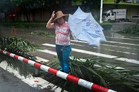 Eine Frau kämpft gegen den Wind in Yangjiang, China.
