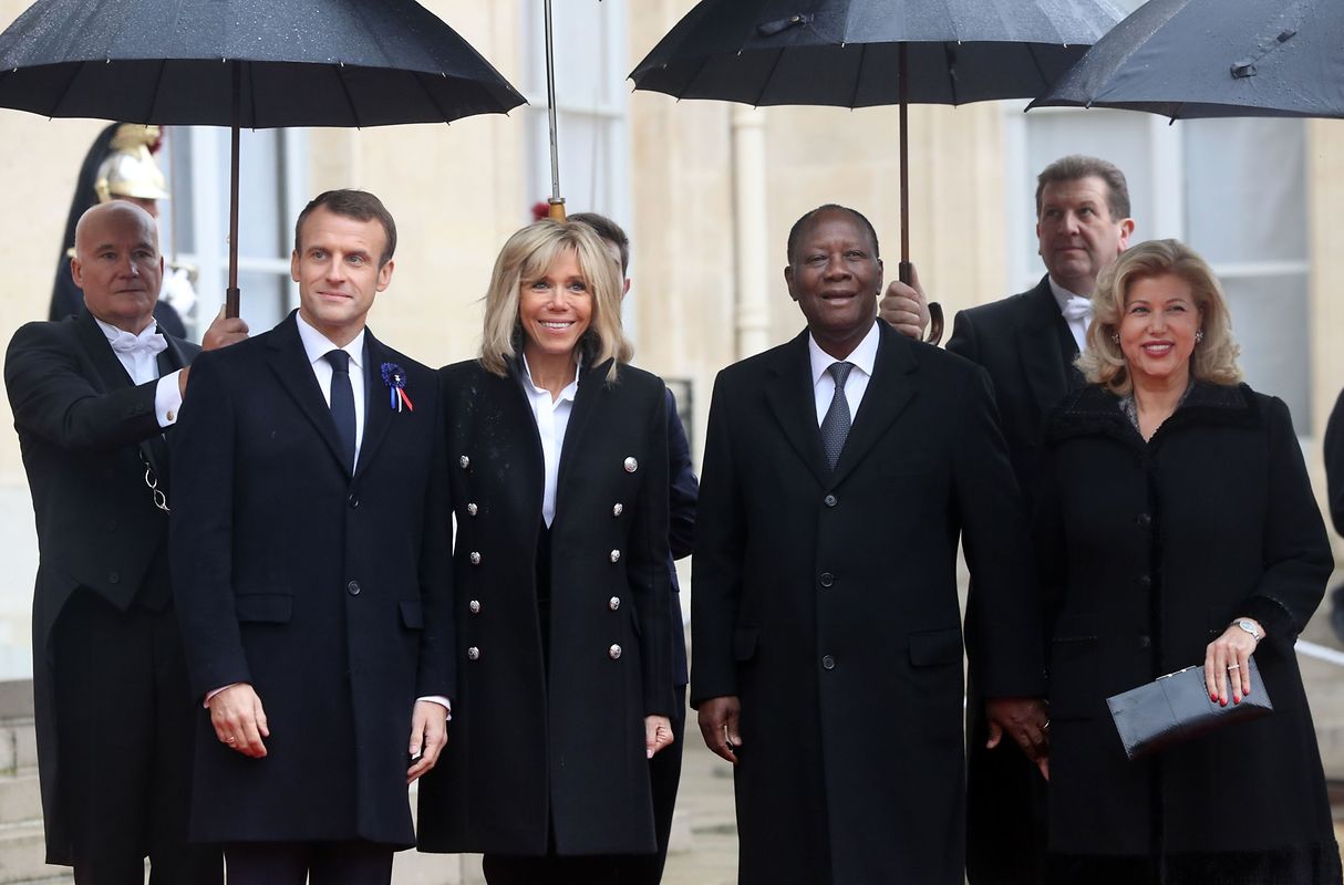 French President Emmanuel Macron (L) and his wife Brigitte Macron welcome Ivorian President Alassane Ouattara and his wife Dominique Ouattara at the Elysee Palace in Paris on November 11, 2018 ahead of the start of commemorations marking the 100th anniversary of the 11 November 1918 armistice, ending World War I. (Photo by Jacques Demarthon / AFP)