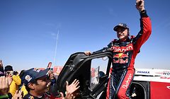 First-placed for the auto category Mini JCW X-RAID Team Spain's driver Carlos Sainz (R), celebrates as he gets out of his car while second-placed Toyota's team Qatar's driver Nasser Al-Attiyah (C) applauds him, on the finish area in Qiddiya at the end of the stage 12 of the Dakar 2020 between Haradh and Qiddiya, Saudi Arabia, on January 17, 2020. (Photo by FRANCK FIFE / AFP)