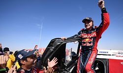 First-placed for the auto category Mini JCW X-RAID Team Spain's driver Carlos Sainz (R), celebrates as he gets out of his car while second-placed Toyota's team Qatar's driver Nasser Al-Attiyah (C) applauds him, on the finish area in Qiddiya at the end of the stage 12 of the Dakar 2020 between Haradh and Qiddiya, Saudi Arabia, on January 17, 2020. (Photo by FRANCK FIFE / AFP)