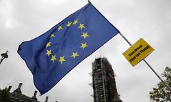 An anti-Brexiteer waves an EU flag near the Houses of Parliament in Westminster, central London on October 17, 2019. - Britain's Prime Minister Boris JohnsonA and the European Union on Thursday reached a provisional agreement that might just see Britain leave the European Union by the October 31 deadline. (Photo by Tolga AKMEN / AFP)