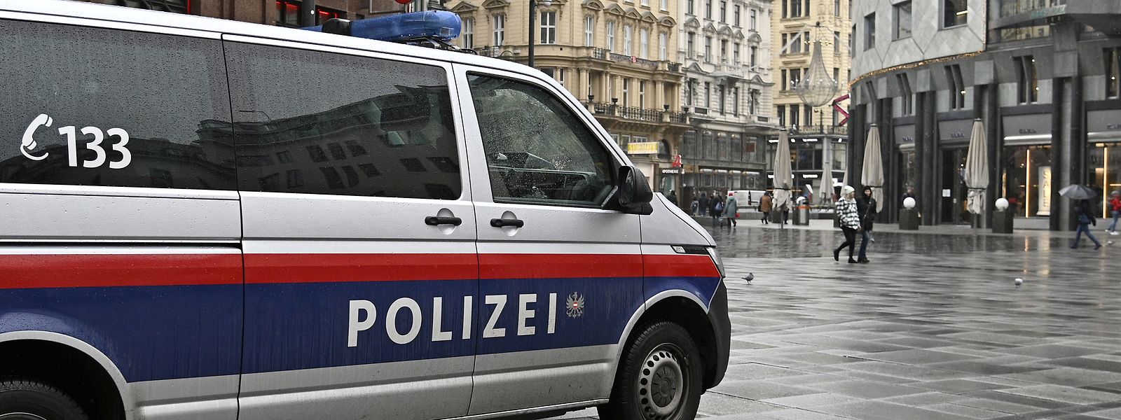 Ein Polizeiauto fährt durch eine Einkaufsstraße. Österreich geht wegen der Corona-Krise erneut in einen Lockdown und wird im Februar eine Impfpflicht einführen.