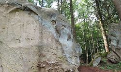 Eine Frau mit Kopf und ein Mann ohne Kopf sind an diesem Felsen zu sehen.