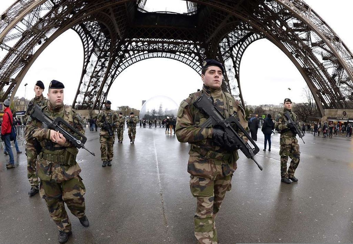 French soldiers patrol in front of the Eiffel Tower on January 8, 2015 in Paris. France announced an unprecedented deployment of thousands of troops and police to bolster security at "sensitive" sites including Jewish schools Monday, the day after marches that drew nearly four million people across the country in tribute to the 17 victims of a three-day killing spree in Paris. The killings began on January 7 with an assault on the Charlie Hebdo satirical magazine in Paris that saw two brothers massacre 12 people including some of the country's best-known cartoonists and the storming of a Kosher supermarket on the eastern fringes of the capital which killed 4 local residents. AFP PHOTO / BERTRAND GUAY AFP/AFP/BERTRAND GUAY/STF /tsc
