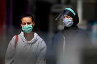People wearing protective face masks walk in Rue Neuve, a shopping street in Brussels centre on May 9, 2020, amid the country's lockdown to stem the spread of the COVID-19 outbreak caused by novel coronavirus. - Shops in Belgium will reopen on May 11, 2020. (Photo by JOHN THYS / AFP)