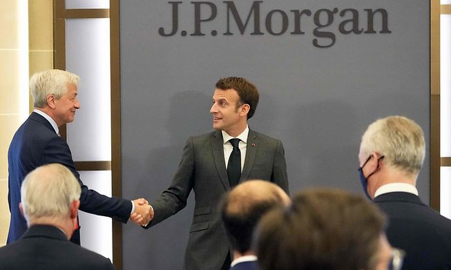 French President Emmanuel Macron shakes hands with JP Morgan CEO Jamie Dimon (left) at the opening of the bank's new headquarters in Paris on Tuesday
