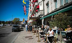 People have lunch at a restaurant in Stockholm on April 22, 2020, during the coronavirus COVID-19 pandemic. (Photo by Jonathan NACKSTRAND / AFP)