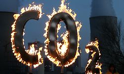 ARCHIV - 17.11.2008, Hessen, Hanau: Mit einem brennenden "CO 2-Zeichen" demonstrieren Mitglieder der Umweltschutzorganisation Greenpeace vor dem Kohlekraftwerk Staudinger in Hanau gegen den Schadstoffausstoß des Kraftwerkes. (zu dpa «UN-Bericht: Klimawandel gefährdet Nachhaltigkeitsziele») Foto: Boris Roessler/dpa +++ dpa-Bildfunk +++