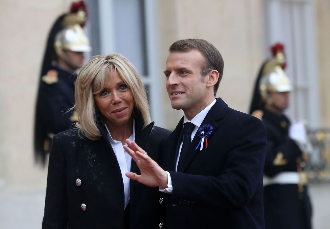 French President Emmanuel Macron (R) and his French President's wife Brigitte Macron wait for guests arriving at the Elysee Palace in Paris on November 11, 2018 ahead of the start of commemorations marking the 100th anniversary of the 11 November 1918 armistice, ending World War I. (Photo by Jacques Demarthon / AFP)