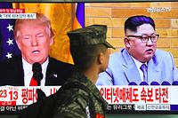 A South Korean soldier walks past a television screen showing pictures of US President Donald Trump (L) and North Korean leader Kim Jong Un at a railway station in Seoul on March 9, 2018. 
US President Donald Trump agreed on March 8 to a historic first meeting with North Korean leader Kim Jong Un in a stunning development in America's high-stakes nuclear standoff with North Korea. / AFP PHOTO / Jung Yeon-je