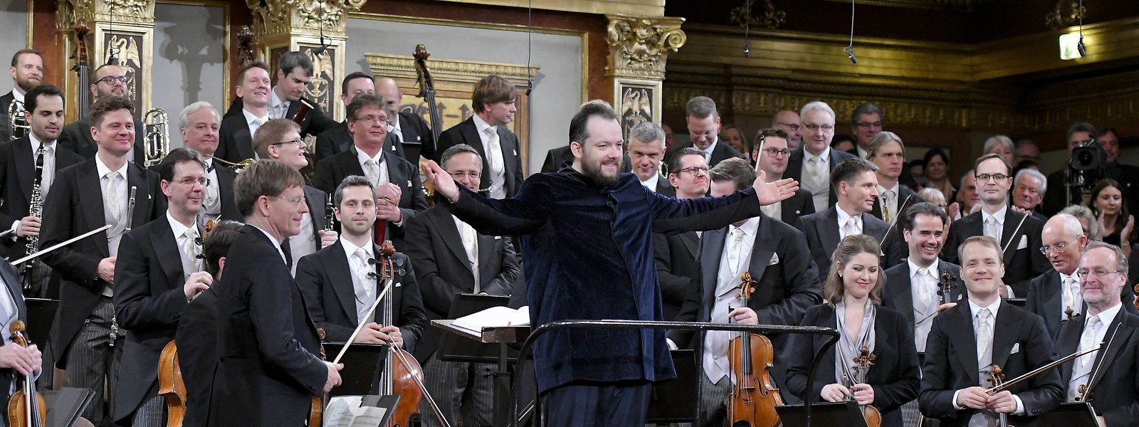 Andris Nelsons (M), Dirigent aus Lettland, steht nach dem Neujahrskonzert der Wiener Philharmoniker im Wiener Musikverein vor dem Orchester und bedankt sich beim Publikum. 