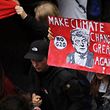 A protester holds up a sign reading "Make climate change great again" while taking part in the "solidarity without borders instead of G20" demonstration on July 8, 2017 in Hamburg, northern Germany as world leaders meet during the G20 summit. / AFP PHOTO / STEFFI LOOS