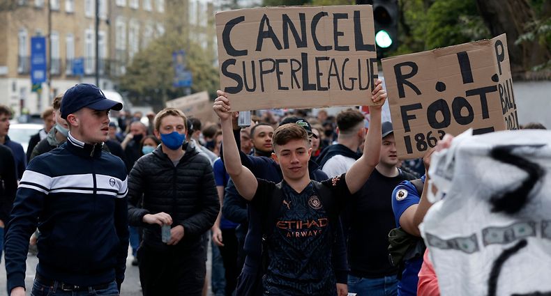 Football supporters demonstrate against the proposed European Super League outside of Stamford Bridge football stadium in London on April 20, 2021, ahead of the English Premier League match between Chelsea and Brighton and Hove Albion. - Reports on Tuesday evening suggested that cracks were appearing in the plan with some clubs having second thoughts in the face of the outrage. British media named Chelsea as one team that could be on the brink of pulling out of the project. (Photo by Adrian DENNIS / AFP)