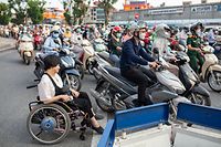  Hieu Luu (vorn) ist während der Hauptverkehrszeit unterwegs, ebenso wie unzählige Motorroller. Sich in der Metropole fortzubewegen ist schon für Menschen ohne Handicap eine Herausforderung und noch mehr für Rollstuhlfahrer. 