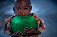 A displaced child chew on an empty plate in a abandoned church, Saturday, Nov. 15, 2008 in Kibati just north of Goma in eastern Congo. The U.N. refugee agency plans to move 60,000 Congolese caught between the front lines in the east of the country to a new camp next week. (AP Photo/Karel Prinsloo)