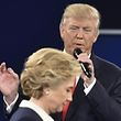 TOPSHOT - Republican presidential candidate Donald Trump speaks as Democratic presidential candidate Hillary Clinton walks past during the second presidential debate at Washington University in St. Louis, Missouri on October 9, 2016. / AFP PHOTO / Paul J. Richards