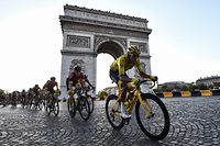 TOPSHOT - Colombia's Egan Bernal (R), wearing the overall leader's yellow jersey (C-R) and cyclists ride down the Champs Elysees avenue next to the Arc de Triomphe during the 21st and last stage of the 106th edition of the Tour de France cycling race between Rambouillet and Paris Champs-Elysees, in Paris, on July 28, 2019. (Photo by Anne-Christine POUJOULAT / AFP)