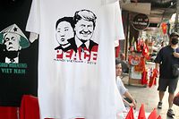21.02.2019, Vietnam, Hanoi: T-Shirts, auf denen die Porträts des US-Präsidenten Trump und des nordkoreanischen Machthabers Kim über dem Schriftzug "Peace" zu sehen sind, hängen an einem Verkaufsstand. (zu dpa "Kegelhut-Trump und «Peace» mit Kim: T-Shirts sind in Hanoi der Renner" Foto: Bac Pham/dpa +++ dpa-Bildfunk +++