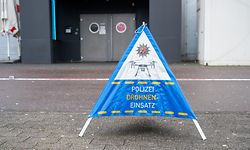 17.02.2023, Rheinland-Pfalz, Trier: Ein Schild steht auf dm Pflaster an einer Stelle, an der Polizisten von der Spurensicherung mit einer Drohne und einer Spezialkamera Bereiche eines Tatorts um eine Discothek untersuchen. Dort haben in der Nacht etwa 40 Personen mehrere Polizisten angegriffen und teilweise verletzt. Foto: Harald Tittel/dpa +++ dpa-Bildfunk +++