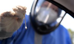 05.08.2020, Rheinland-Pfalz, Bitburg: Eine ehrenamtliche Helferin des Deutschen Roten Kreuzes (DRK) im Schutzanzug nimmt mit einem Wattestäbchen bei einem Urlaubsrückkehrer eine Probe, die auf das Coronavirus getestet wird. Bitburg ist die erste von vier Teststationen in Rheinland-Pfalz, in denen sich rheinland-pfälzische Reiserückkehrer testen lassen können. Drei weitere Teststationen gehen am Donnerstag in Betrieb. Foto: Harald Tittel/dpa +++ dpa-Bildfunk +++