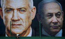 (FILES) In this file photo taken on February 17, 2020 (FILES) A file photo taken on February 17, 2020 shows an election banner for the Israeli Blue and White political alliance (Kahol Lavan) with the face of (L to R) its leader retired army general Benny Gantz and Prime Minister Benjamin Netanyahu, hanging in Ramat Gan. - Israeli Prime Minister Benjamin Netanyahu and his former rival, parliament speaker Benny Gantz, agreed to form an emergency unity government on April 20, 2020, ending the worst political crisis in the country's history. (Photo by JACK GUEZ / AFP)