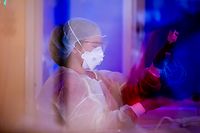 29.12.2021, Berlin: Eine Intensivfachpflegerin betreut auf der Intensivstation des Gemeinschaftskrankenhauses Havelhöhe einen Covid-19-Patienten. Foto: Christoph Soeder/dpa +++ dpa-Bildfunk +++