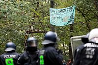 Environmental activists sit in a so-called Tripod tree house as riot police arrive to clear the Hambacher Forst forest in Kerpen, western Germany, on September 13, 2018. - German activists living in treehouses to protect the ancient forest from being razed for a nearby coal mine were bracing for a forced eviction by police, in a major escalation of the long running environmental battle. (Photo by Marius Becker / dpa / AFP) / Germany OUT