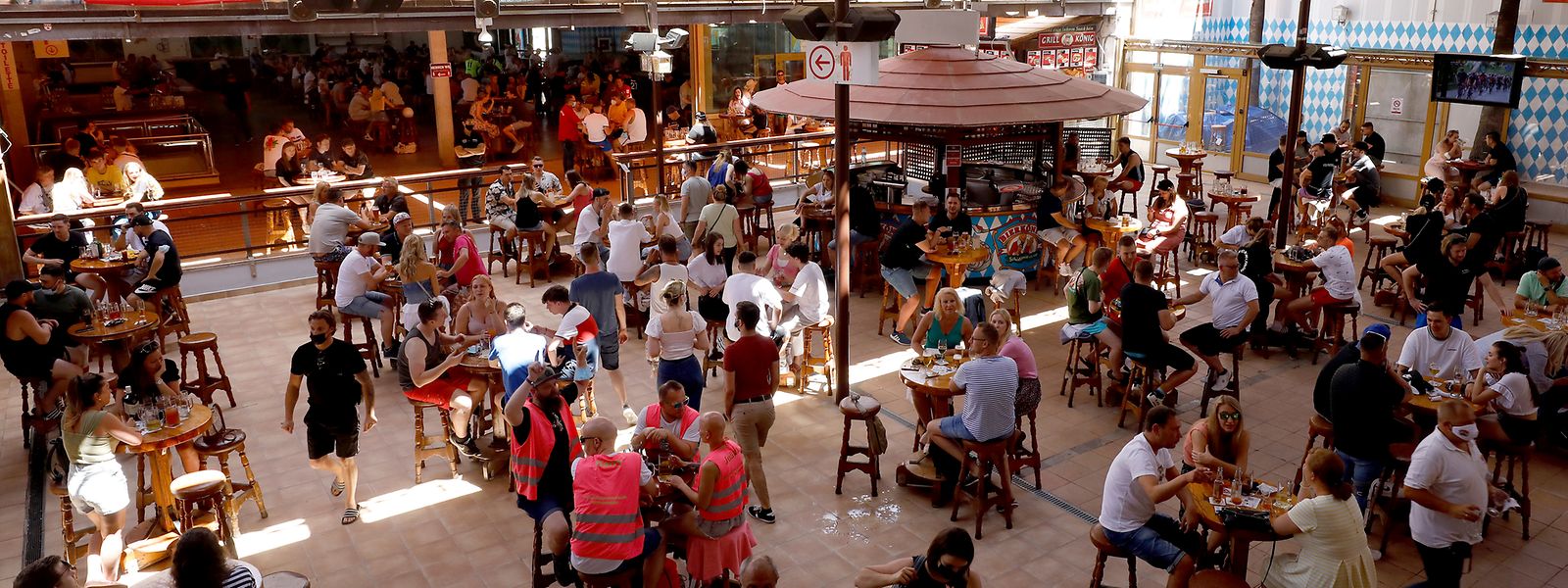 Gäste sitzen an Tischen im Lokal «Bierkönig» auf Mallorca. Das Lokal hat nach Monaten der Schließung wieder geöffnet. Allerdings gelten noch diverse Corona-Auflagen für die Gäste.