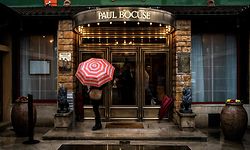 (FILES) In this file photo taken on January 20, 2018 A person waits at the entrance to the restaurant of French chef Paul Bocuse restaurant, 'L'auberge du Pont de Collonges' in Collonges-au-Mont-d'Or, near Lyon. (Photo by JEFF PACHOUD / AFP)